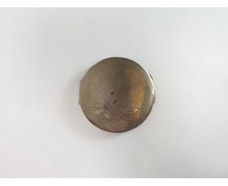 A silver powder compact, Birmingham 1952, with Coronation mark, engine turned with a spray of flowers, 7cm diameter