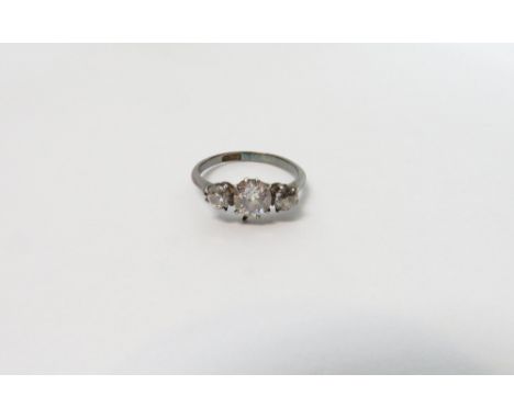 A three stone diamond ring, the white mount stamped '18ct', the graduated old brilliant cuts totalling approximately 0.9 cara