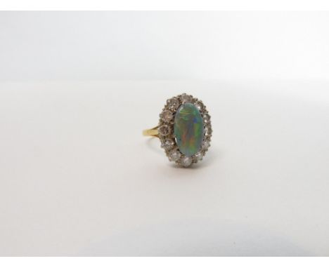 An opal and diamond cluster ring, the mount stamped '18ct Plat', the oval cut shallow cabochon measuring approximately 13.3 m