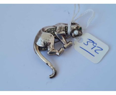 A silver leopard brooch with green set eyes and pearl in mouth 