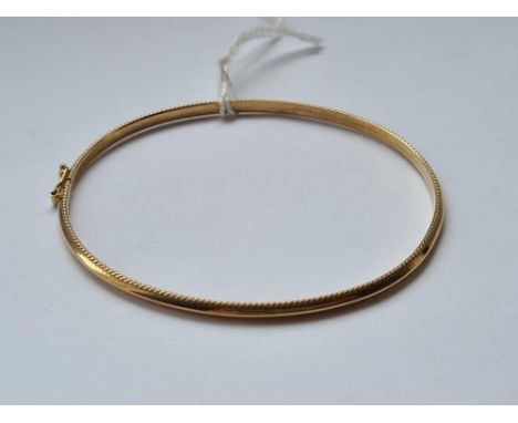 A patterned bangle twist opening with security clasp 9ct 