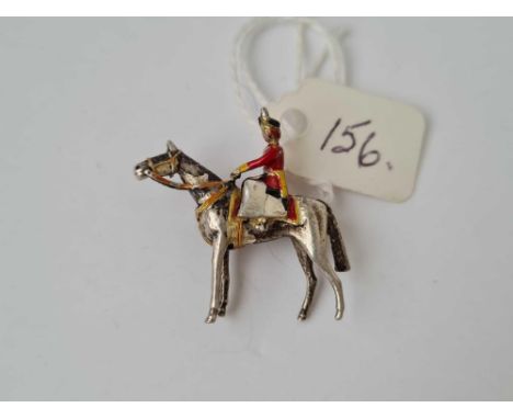 A silver and enamel brooch depicting the queen on horse back at trooping of the colour 