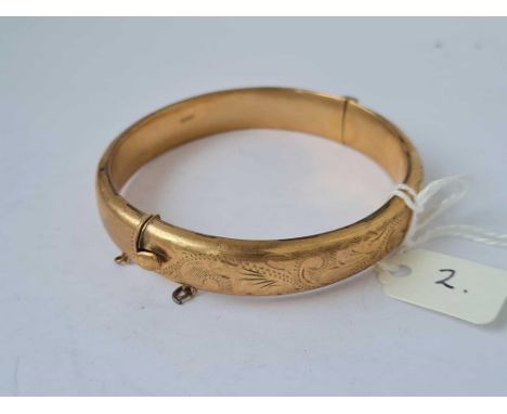 A HINGED BANGLE ENGRAVED WITH SCROLLS 9CT - 14.8 GMS 