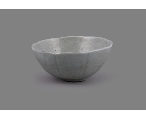 An attractive Chinese pale celadon lobed bowl, Qing Dynasty, 18th century, after a Song original, the exterior with eight ver