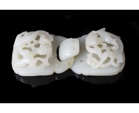 A Chinese pale celadon jade buckle, 18th century, Qing Dynasty, each section with carved and pierced dragons to the top side,