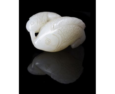 A Chinese white jade 'Fish' pendant, 18th/19th century, the two fish with incised details of the tail and fins and holding a 