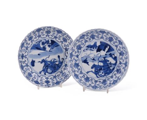 A pair of Chinese porcelain blue and white circular saucer dishes, Kangxi, 1662-1722, each with fluted body and foliate rim, 