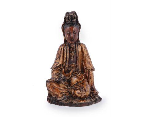 A Chinese gilt-lacquer and carved wood figure of Guanyin, Qing Dynasty, 18th century, depicted seated with the right knee rai