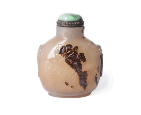A Chinese 'shadow' agate snuff bottle, Qing Dynasty, 19th century, carved with a flower and a bird, the shoulders with mask a
