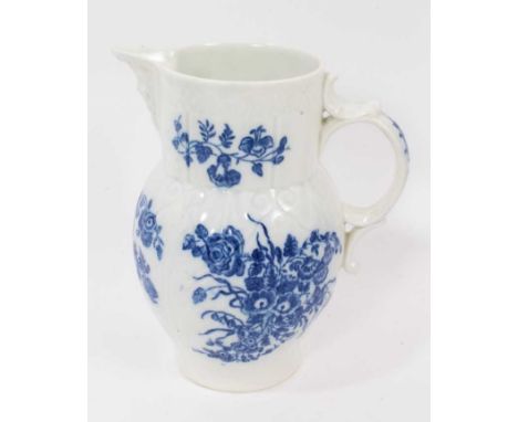 A Caughley blue and white cabbage leaf moulded jug with mask spout, circa 1780, decorated with bouquets of flowers, S mark to