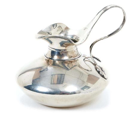 Edwardian Art Deco style silver cream jug of compressed circular form, with flared rim and leaf mounted handle (London 1904) 