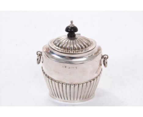 Edwardian silver tea caddy of oval form, with twin ring handles, fluted decoration and hinged domed cover, with turned wood f