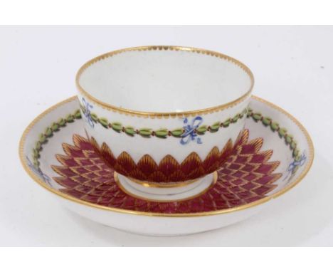A Chelsea-Derby tea bowl and saucer, circa 1770, pineapple-moulded and painted with floral sprays and foliate patterns, on a 