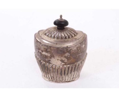 George V silver tea caddy of oval form with fluted decoration, hinged domed cover, with turned wood finial (Birmingham 1912),