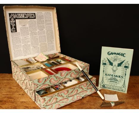 A 1950's Maskelyne's Mysteries box of conjuring tricks by Gamages, Holborn of London, comprising a two-tier compartmented box