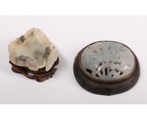 China, two jade carvings, 19th century, one a lotus-shaped washer on a carved wood stand, the other originally the head of a 