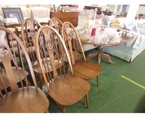 ERCOL MID ELM EXTENDING OVAL DINING TABLE ON SINGLE PEDESTAL (DESIGN 1117), TOGETHER WITH SIX SWAN STICK BACK DINING CHAIRS