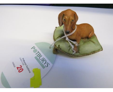 ITALIAN PORCELAIN FIGURINE OF DOG ON CUSHION.
