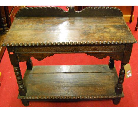 A joined and chip carved oak ledgeback two-tier side table, raised on bobbin turned supports, with single end drawer, width 9