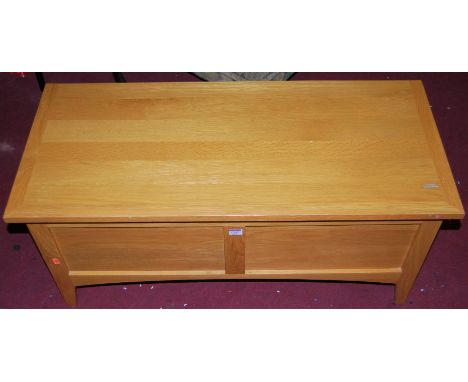 A contemporary light oak twin panelled hinge top blanket box, width 100cm