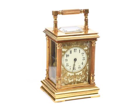 BRASS CARRIAGE CLOCK WITH FOUR GLASS PANELS AND PROCELAIN DIAL WITH GILT FRETWORK FRONT AND ALARM MOVEMENT. HEIGHT: 6 INCHES.