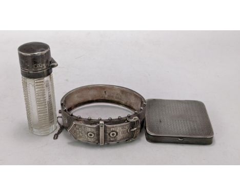 A silver engine turned compact together with a silver bangle and silver topped scent bottleLocation: 