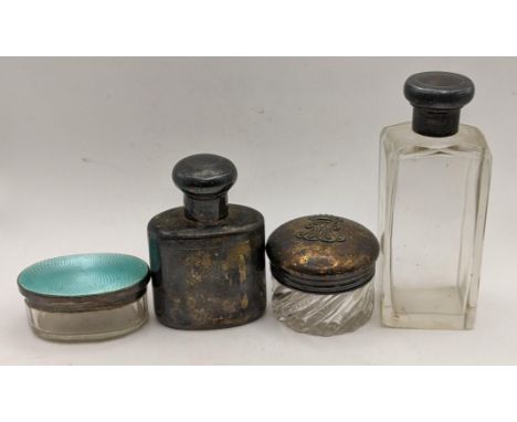 A silver flask with a screw lid, two glass dressing table jars, one with a silver enamelled lid, the other with initials and 