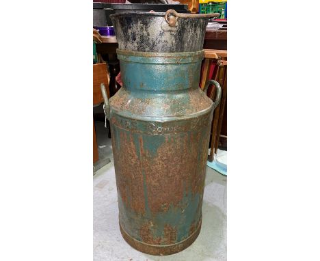 A vintage cast metal Manchester Co-op society milk churn converted into planter with vintage enamel jampan attached to openin