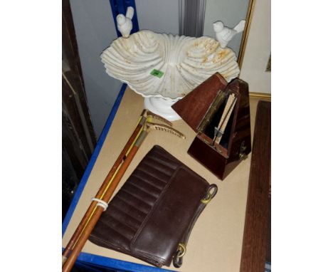 A cast metal painted bird bath in the form of a shell, two vintage riding crops and another and a wooden cased metronome and 