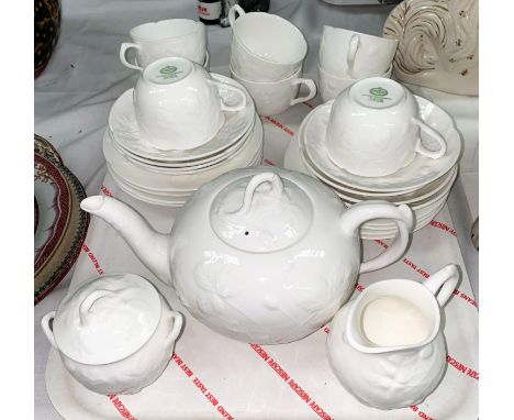 A Mintons Victoria Strawberry eight setting tea service with teapot, milk jug, sugar, cups and saucers, in white with relief 