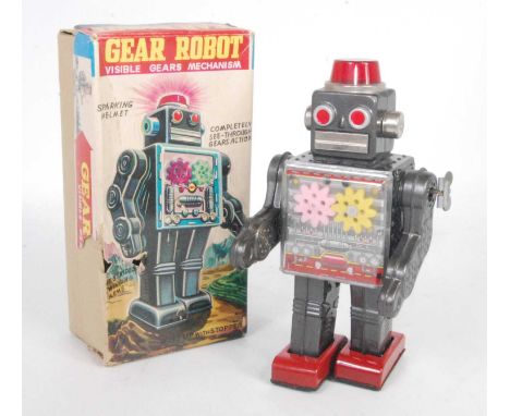 An SH Toys of Japan tinplate and clockwork operated gear robot, comprising grey and silver body with red feet, fixed key mech