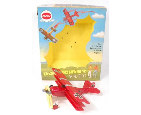 A Cox .049 engine powered line control Dog Fighter air-plane, housed in the original all-card box and fitted with engine, tog