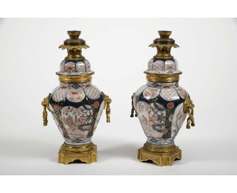 A pair of pots with covers, Japanese porcelain, blue, rouge-de-fer and gilt «Imari» decoration "Flowers" with reserves "Lands