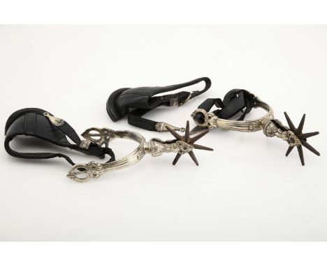A pair of spurs and pair of protectors, silvered bronze, decoration en relief "Leaves", one with leather chain, leather prote