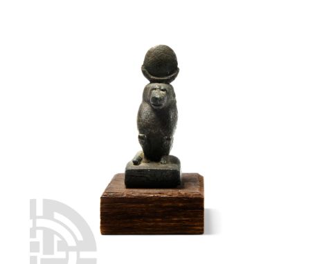 Late Period, 664-525 B.C. In baboon form, modelled in the round wearing a lunar disc and seated on a semi-circular base with 