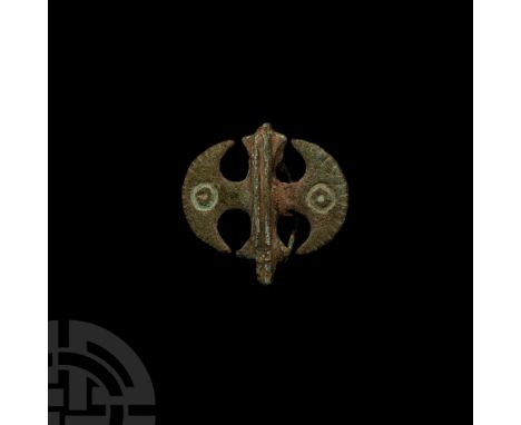 3rd century A.D. Plate brooch with raised vertical shaft and lateral crescent blades each with notched outer edge and incised
