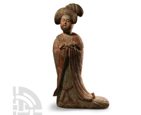 Tang Dynasty, 618-907 A.D. In floor-length courtly dress with hands enfolded within the sleeves; pink and green pigment, on a