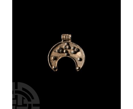 Circa 1st century A.D. Decorated with silver granules and with a gusseted suspension loop to the top edge. 7.46 grams, 31 mm 
