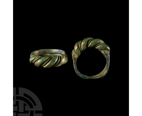 9th-11th century A.D. Featuring hoop composed of overlapping arms, expanded bezel with slender twisted wire strands between l