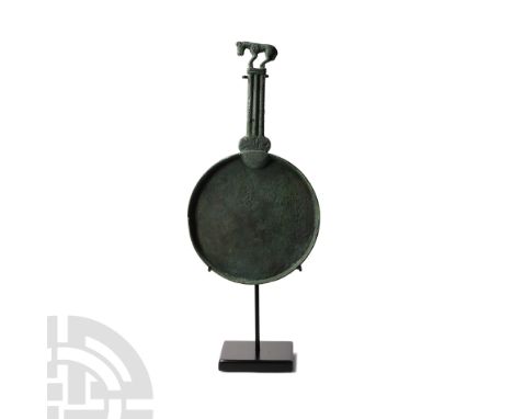 5th-4th century B.C. Comprising a discoid body with raised rim, ribbed handle and openwork stylised panther to the terminal; 
