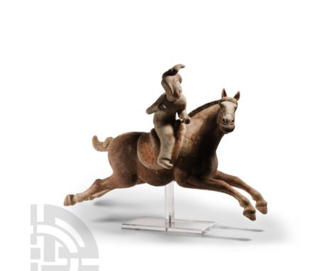 Tang Dynasty, 618-907 A.D. The horse modelled in the round galloping with a polo player in the saddle, poised to swing a mall