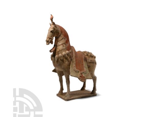 Northern Qi Dynasty, 550-577 A.D. The animal's head raised, mouth open and ears pricked, integrally modelled saddle, capariso
