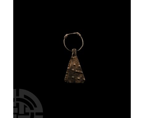 9th-12th century A.D. or earlier. The free-running, wedge-shaped pendant displaying repoussé pellets; slender ring with overl