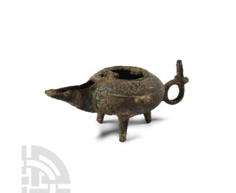 Circa 13th-15th century A.D. The squat spherical body with ring handle and tripod feet, decorated with raised motifs and open