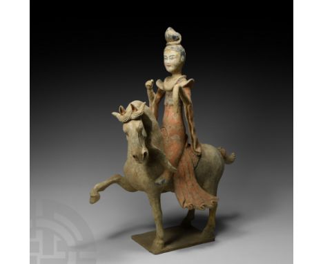 Tang Dynasty, 618-907 A.D. Modelled in the round; the horse in advancing pose with one foreleg raised, copious mane; the fema