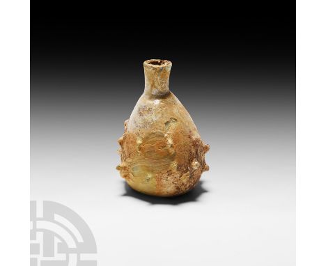 4th-5th century A.D. The lower body decorated with raised 'pimples'; shallow kick-up; iridescent surfaces. 15.9 grams, 58 mm 