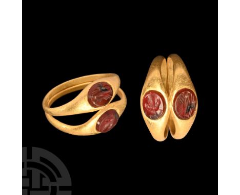 1st century A.D. Bifid hoop expanding to ellipsoid cells, each with an inset garnet cloison, intaglio clasped-hands and chali