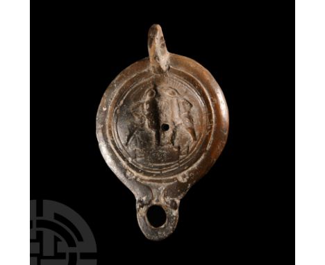 1st-2nd century A.D. Composed of a discoid body with sunken discus bearing a scene of two gladiators in combat in relief, tab