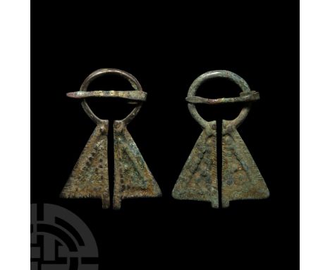 Circa 12th century A.D. Comprising a round-section hoop and two trapezoidal plate finials each with a geometric design of gra