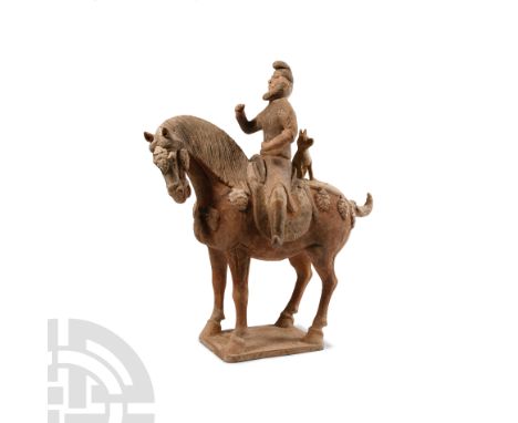 Tang Dynasty, 618-907 A.D. Modelled in the round standing on a rectangular base, the animal's head bowed down and turned slig